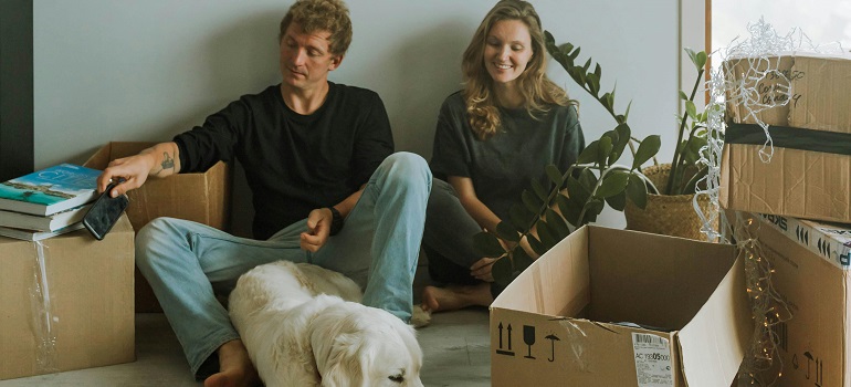 a couple surrounded by the moving boxes