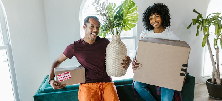 people holding moving boxes